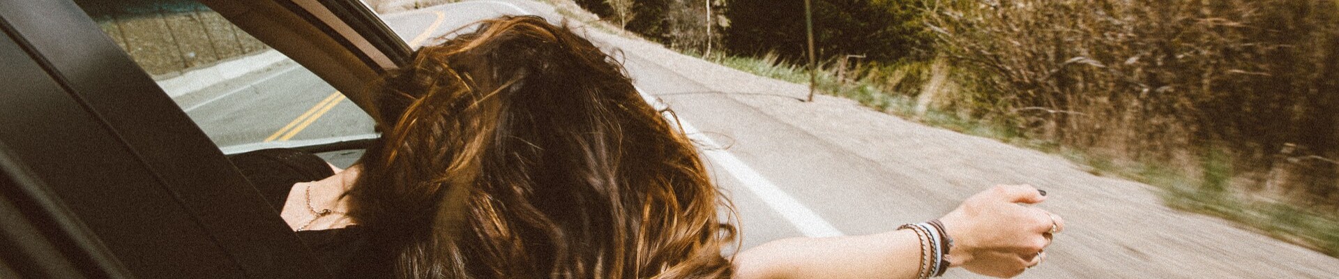 Best Used Cars under $10,000 Phil Long Dealerships Colorado Springs.png Young woman in the passenger seat hanging her arm and head out of the window enjoying the ride as the breezy air blows through her hair