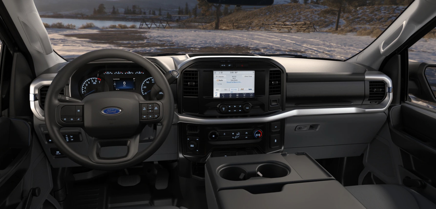 A view
of the 2023 Ford F150s drk gray luxurious interior with large center console
and drink holders, a dash highlight in brushed chrome housing a variety of tech
features including steering wheel convenience buttons, an electronic blue-lit
dash, navigation system, and radio.