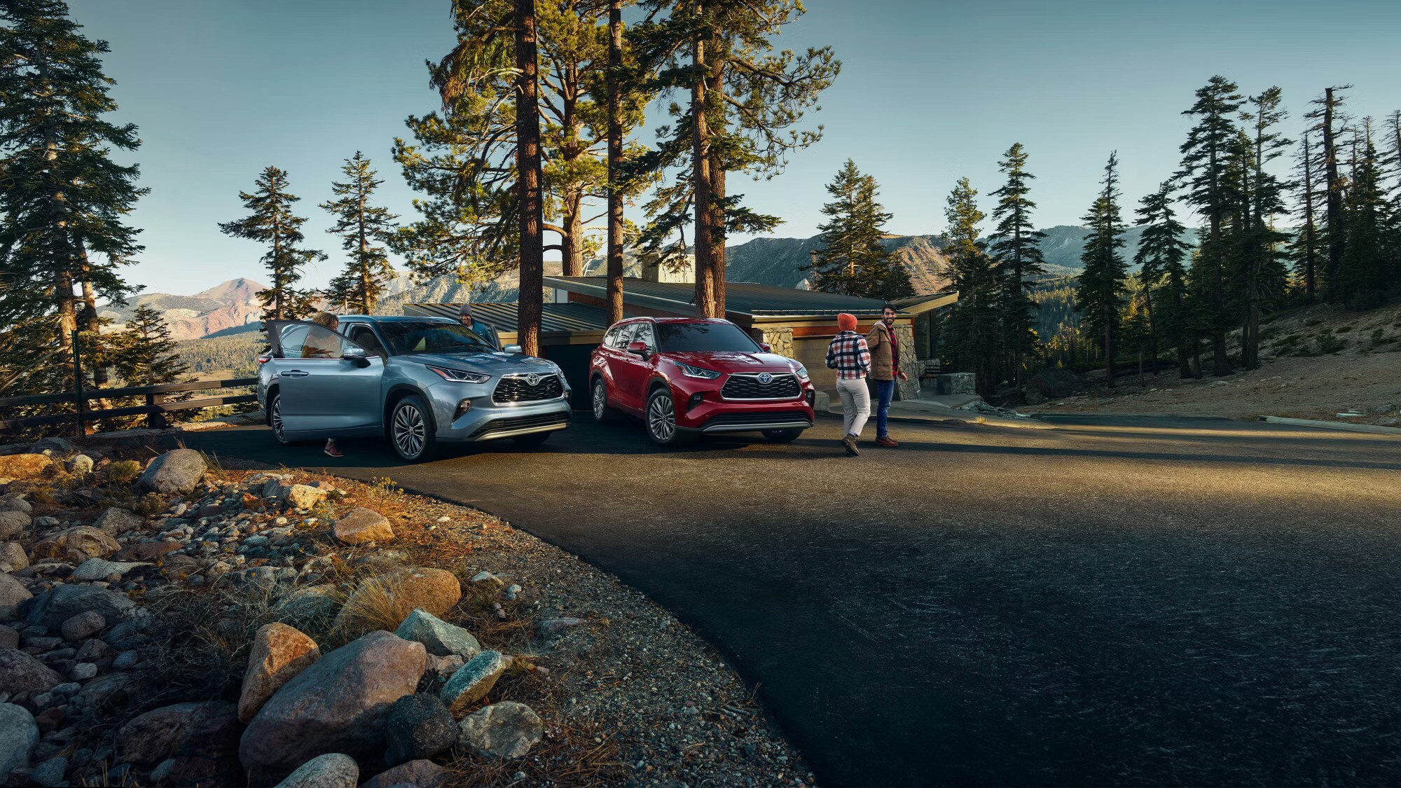 2024%20Highlander.jpg Two 2024 Toyota Highlanders next to eachother next to a mountain cabin overlooking a valley.