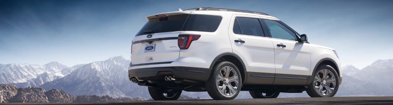 2019 Ford Explorer Configurations Phil Long Ford Denver, CO.png Passenger side view of a white 2019 Ford Explorer parked at the edge of a cliff overlooking a snowing mountain range