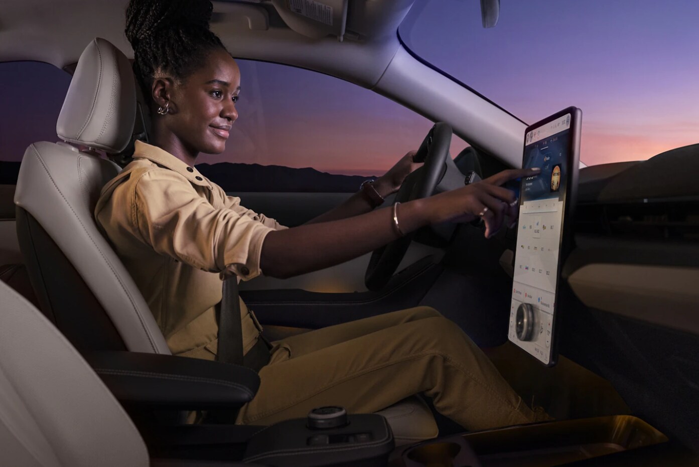 2023-ford-mach-e-9.PNG A woman drives a 2023 Ford Mustang Mach-E and uses the infotainment system