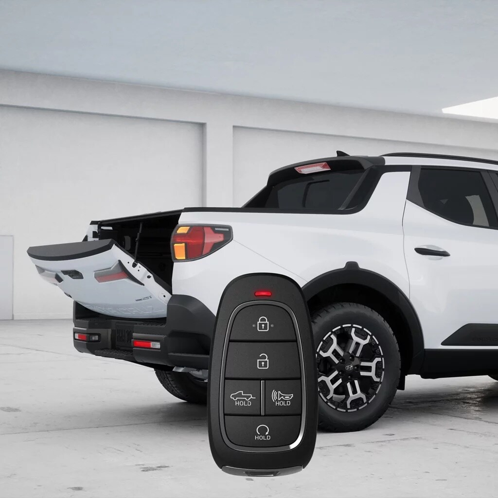 White 2026 Hyundai Santa Cruz XRT with the tailgate open, showing 18-inch XRT alloy wheels and the smart key