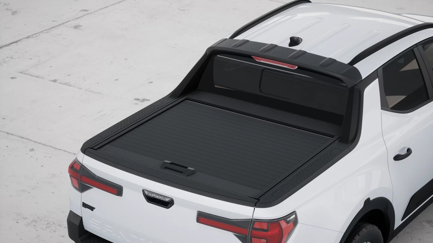 Integrated tonneau cover closed over the bed of a white 2026 Hyundai Santa Cruz XRT