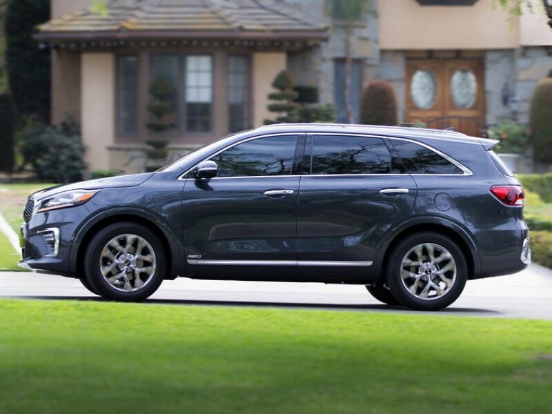 Driver Side Exterior of a gray blue 2019 Kia Sorento driving around down a neighborhood street