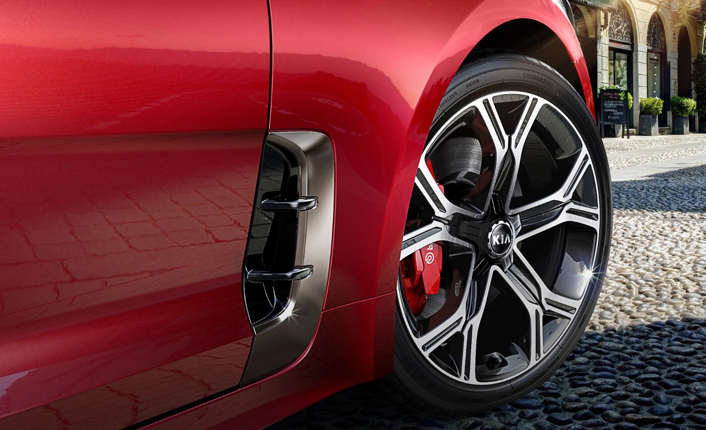 New 2021 Kia Stinger Exterior (1).png Close up view of the front passenger fender showing the smooth chrome/black rims on the new Kia Stinger