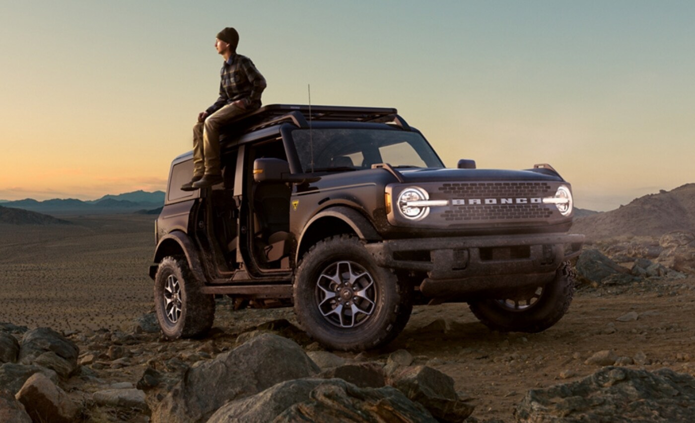 2021 Ford Bronco Badlands Exterior (1).png Profile pic of a new 2021 Ford Bronco Badlands parked by some large desert rocks near sunset