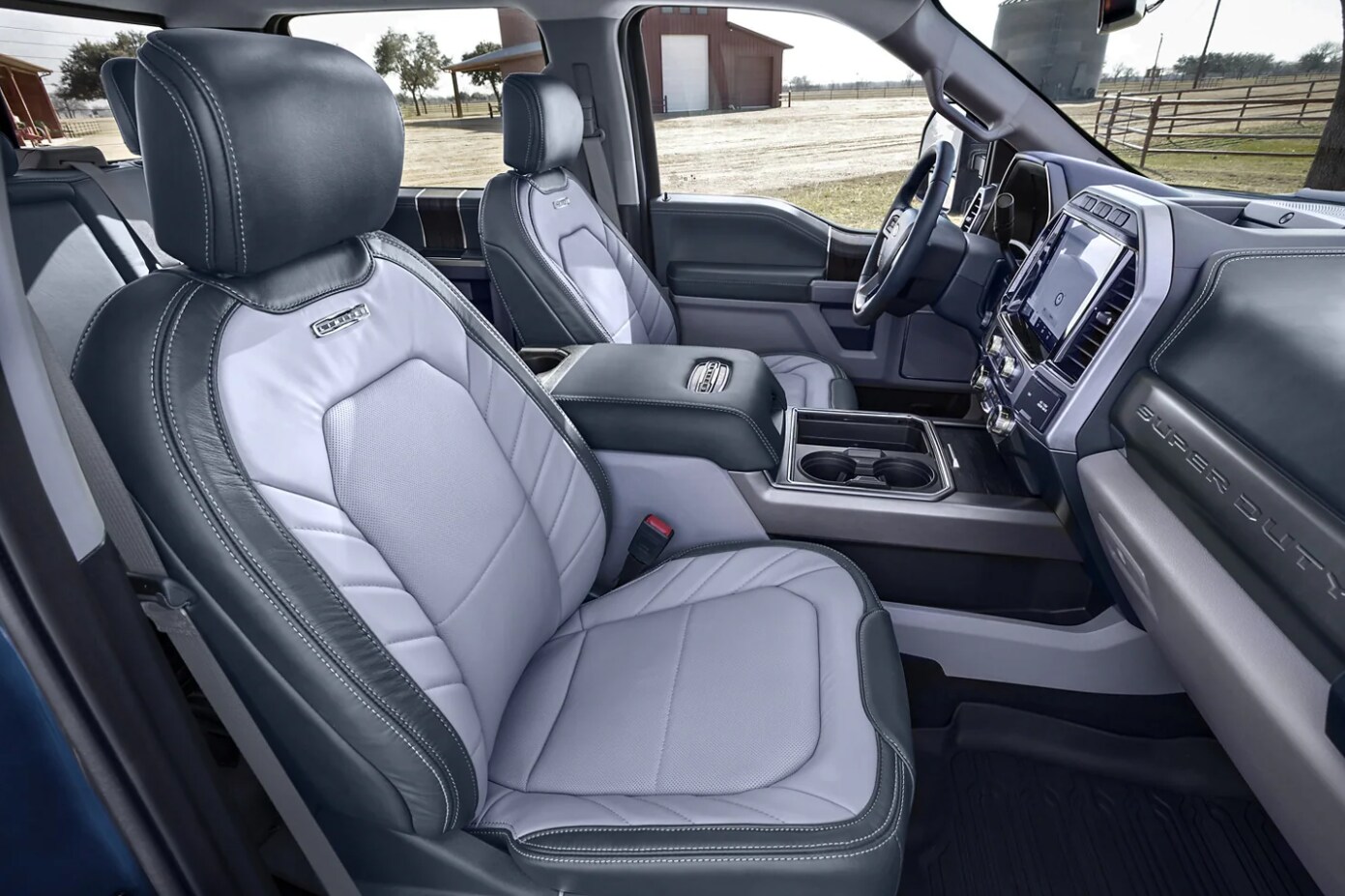 Ford-Super-Duty-4.PNG A blue-gray two-toned leather upholstered cabin of a 2022 Ford Super Duty showing the seats, a large center console, and in-dash infotainment system