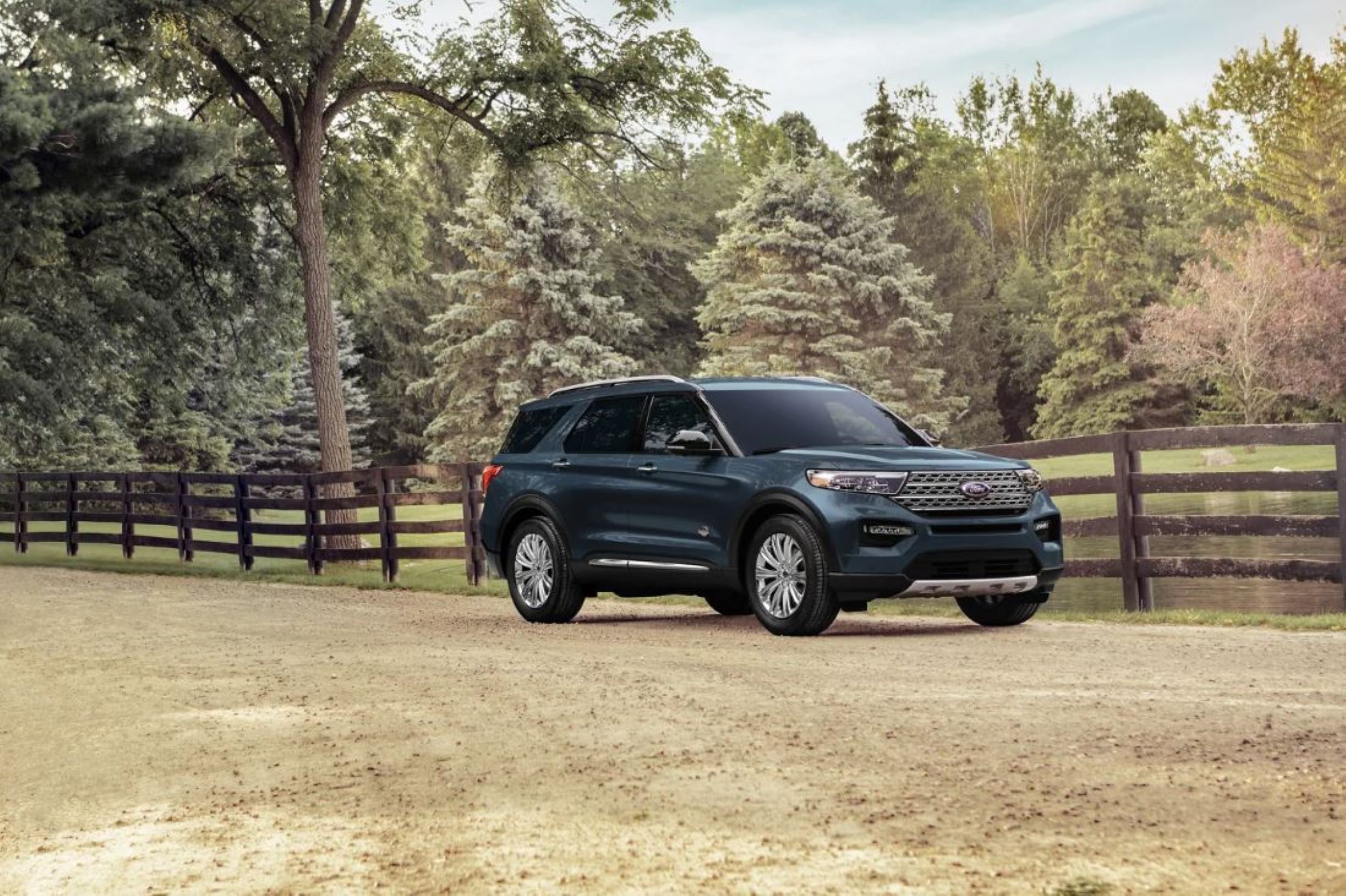Explorer 2024 Blue.JPG A blue Ford Explorer parked with a white fence behind it.