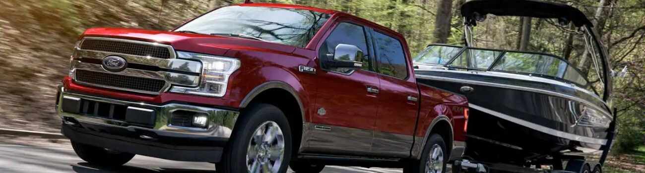 2019 Ford F-150 Towing Capacity Phil Long Ford Motor City Colorado Springs.png Ruby Red 2019 Ford F-150 towing a large boat down a highway