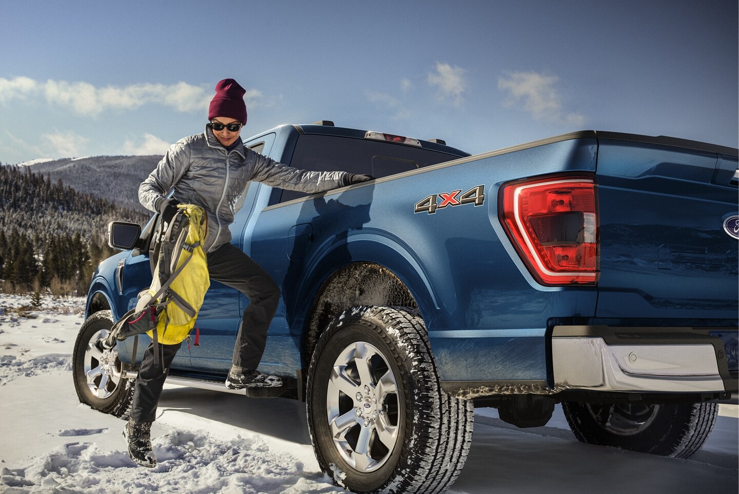 23_FRD_F15_51220.jfif A blue Ford F-150 parked in a snowy field.' class=