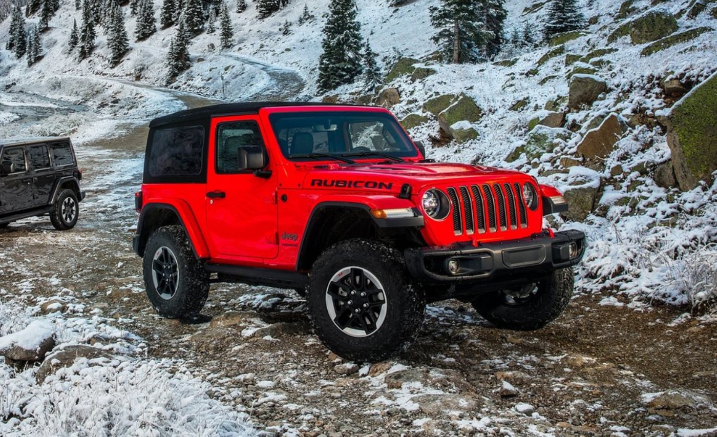 2021 Jeep Wrangler Rubicon Exterior (1).png A red Jeep Wrangler Rubicon 2-door parked on an off-road snowy path in the mountains