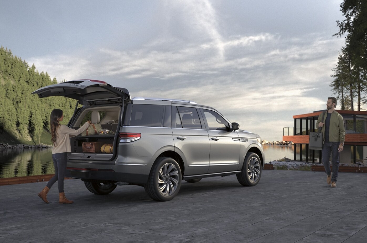 2023 - Lincoln - Navigator -3.PNG A woman removes cargo from the back of a dark gray 2023 Lincoln Navigator