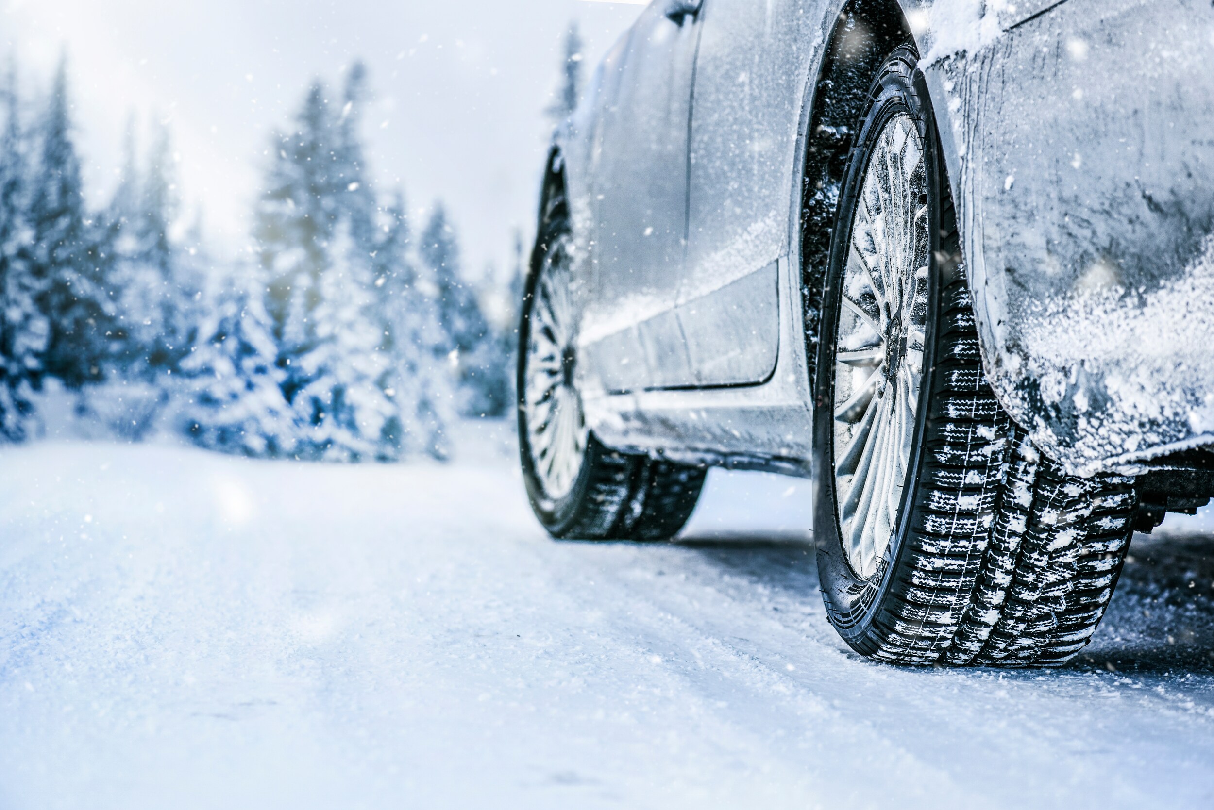 AdobeStock_303086875.jpeg A closeup of a car's tires on a snowy road