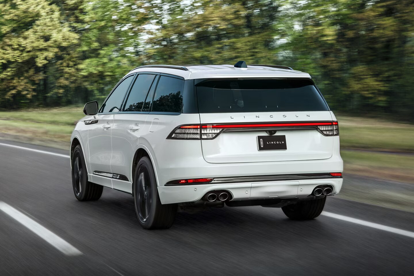 25_LCN_AVI_64119.jpg A white Lincoln Aviator driving down a road.