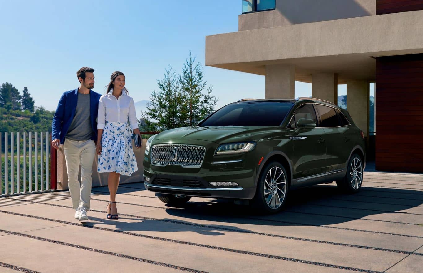 2022 Lincoln Nautilus Exterior A green 2022 Lincoln Nautilus SUV parked in the driveway of a house with a couple walking past