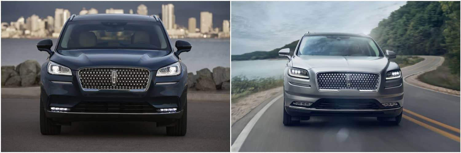 2022 Lincoln Corsair vs Nautilus A navy blue 2022 Lincoln Corsair parked by the rocky shore of a lake with a city in the background, and a silver 2022 Lincoln Nautilus driving down a winding lakeside road