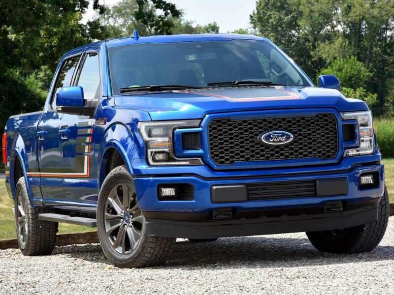Exterior of a blue 2019 Ford F-150 parked on a gravel road beside a forest
