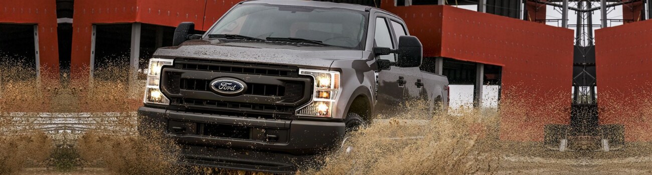 2020 Ford Super Duty F250 in Raton, NM Phil Long Ford.png 2020 Ford Super Duty F-250 plowing through a muddy puddle construction site