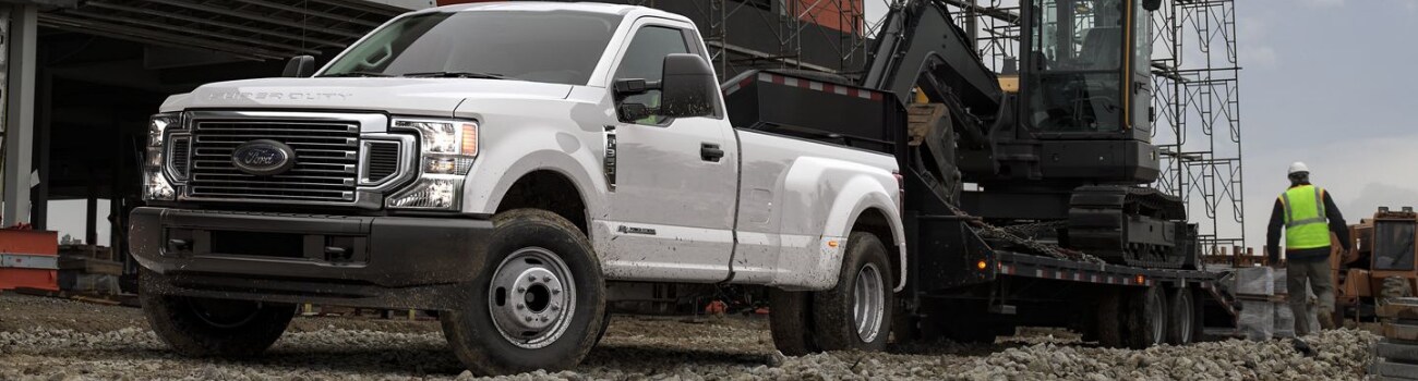 2020 Ford Super Duty towing capacity in Raton, NM Phil Long Ford.png 2020 Ford Super Duty in white towing heavy large construction equipment