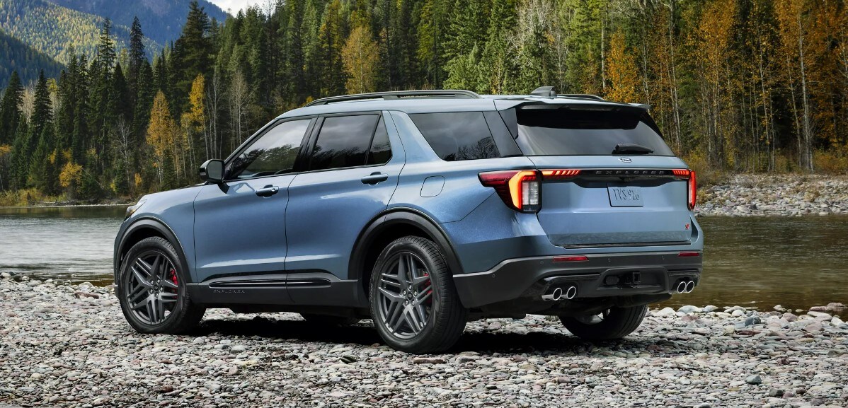 2025%20Ford%20Explorer.2.jpg A blue metallic 2025 Ford Explorer sits parked on top of a rocky off road terrain.