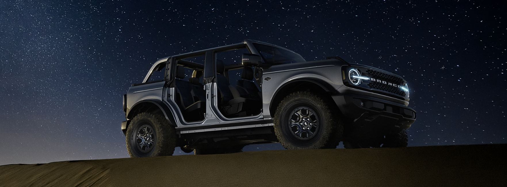 2024 Bronco Night Sky.JPG A Ford Bronco on top of a sand dune with a starry sky behind it