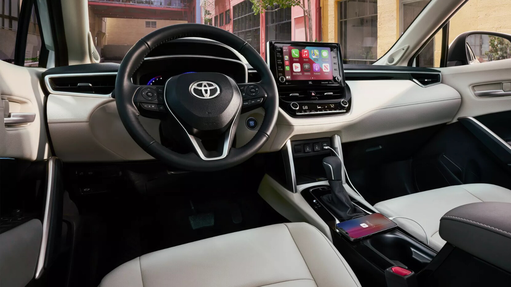 2022-Toyota-Corolla-Cross-4.PNG A view of the dash of the 2022 Toyota Corolla Cross showing an off-white and black interior, an infotainment screen mounted center top of the dash