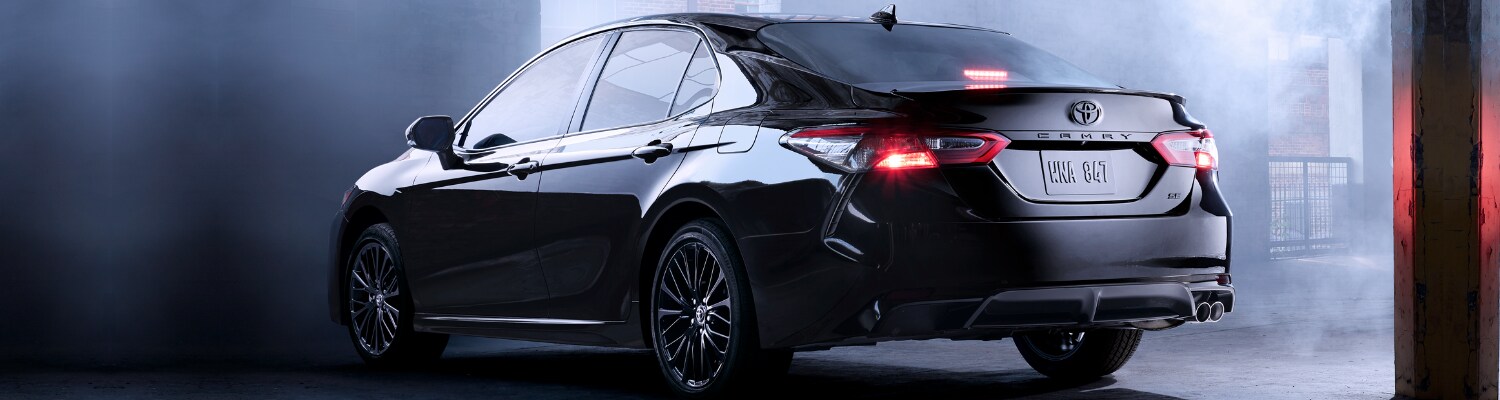 2019 Toyota Camry black exterior in Colorado at Phil Long Toyota Trinidad.png 2019 Toyota Camry rear driver side view parked in a smokey hazy dark garage