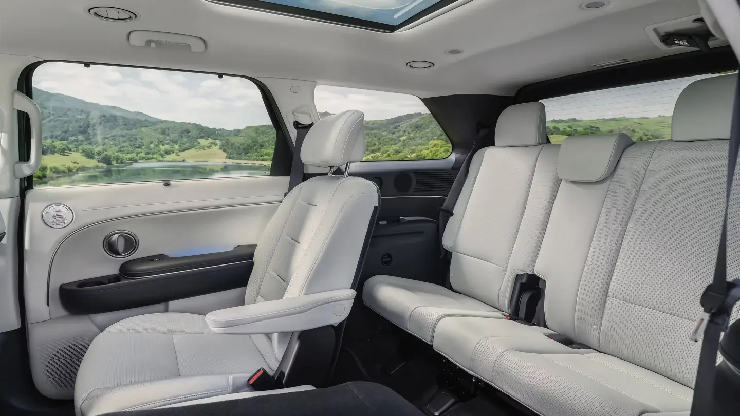 Second and third row seating inside a 2027 Hyundai Palisade viewed from the side door
