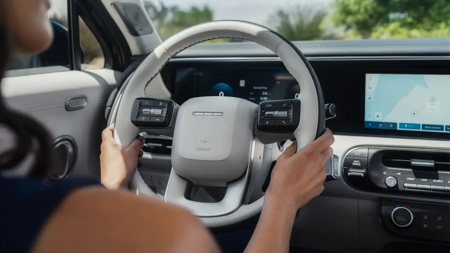 Driver holding the light gray steering wheel of a Hyundai Palisade Calligraphy