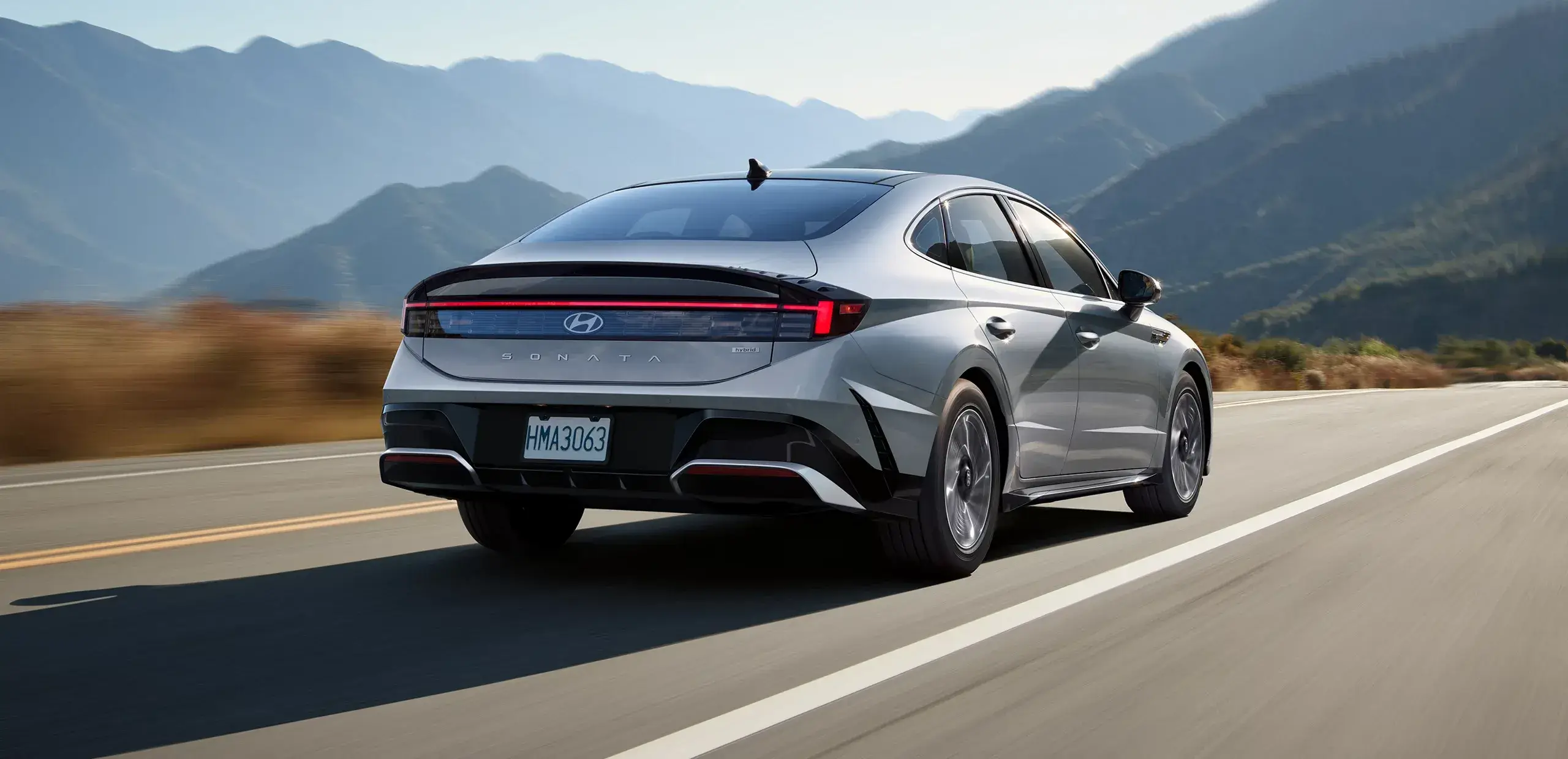 Rear three-quarter view of the Hyundai Sonata Hybrid showing the H-shaped taillight signature and spoiler-shaped trunk lid