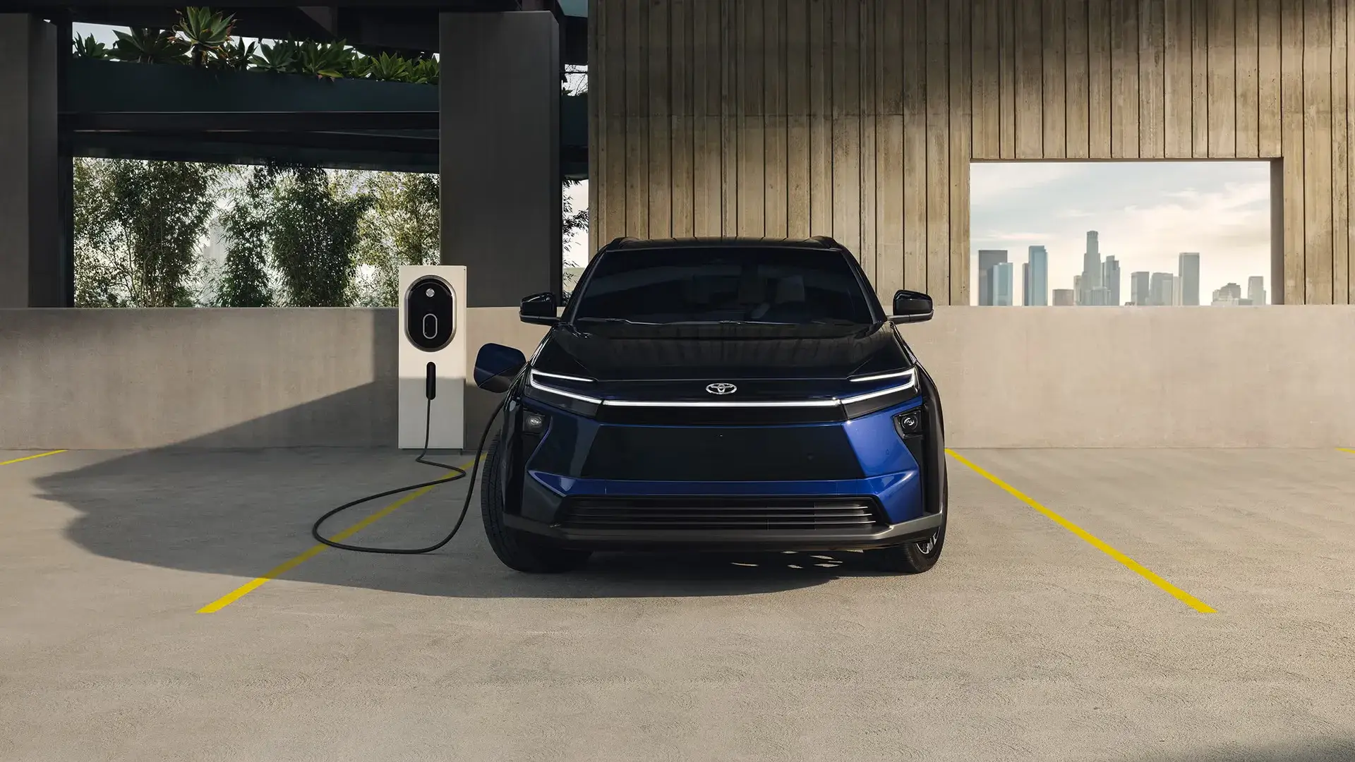 2027 Toyota bZ shown head-on while plugged in and charging