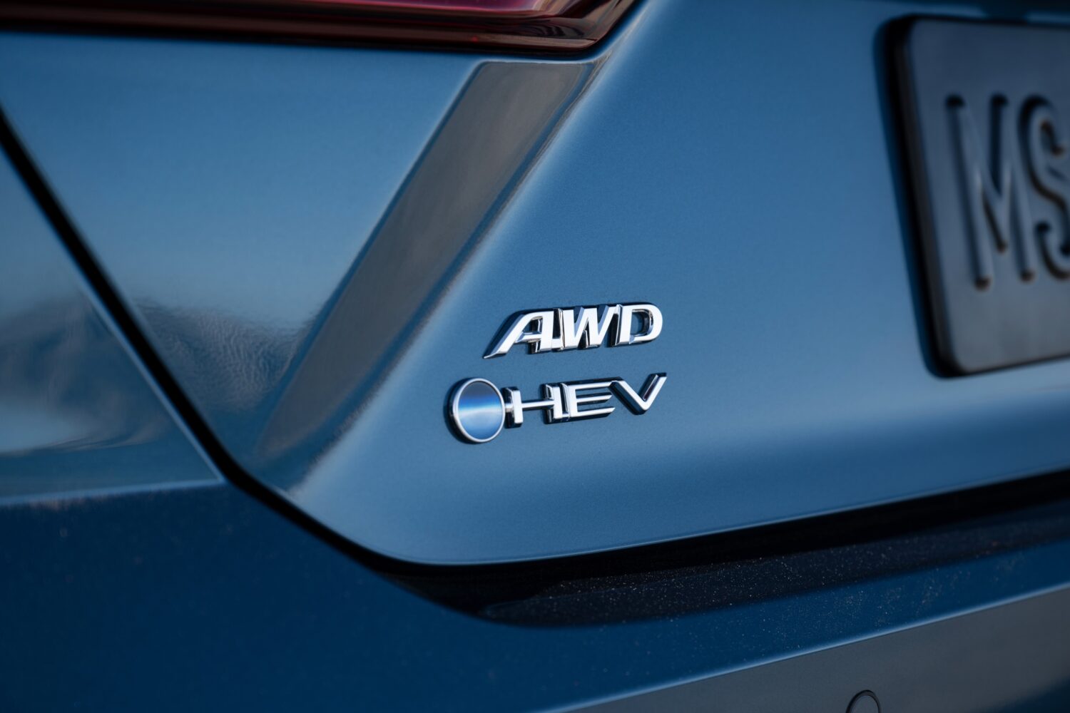 Rear badging on a Toyota Camry XLE showing the HEV and AWD designations