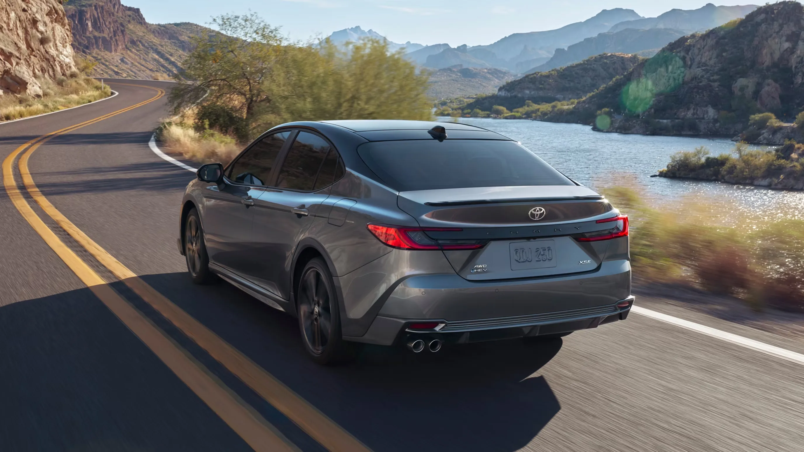Rear three-quarter view of the Toyota Camry showing the taillights and decklid spoiler