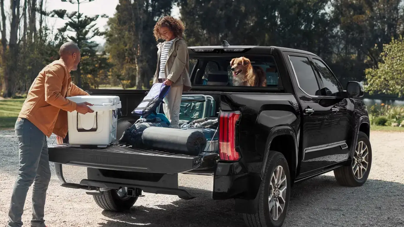 Child playing in the bed of a 2027 Toyota Tundra seen from the rear three-quarter view