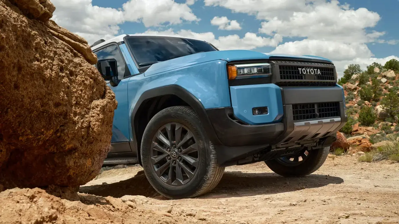 2027 Toyota Land Cruiser front three-quarter view on an unpaved road
