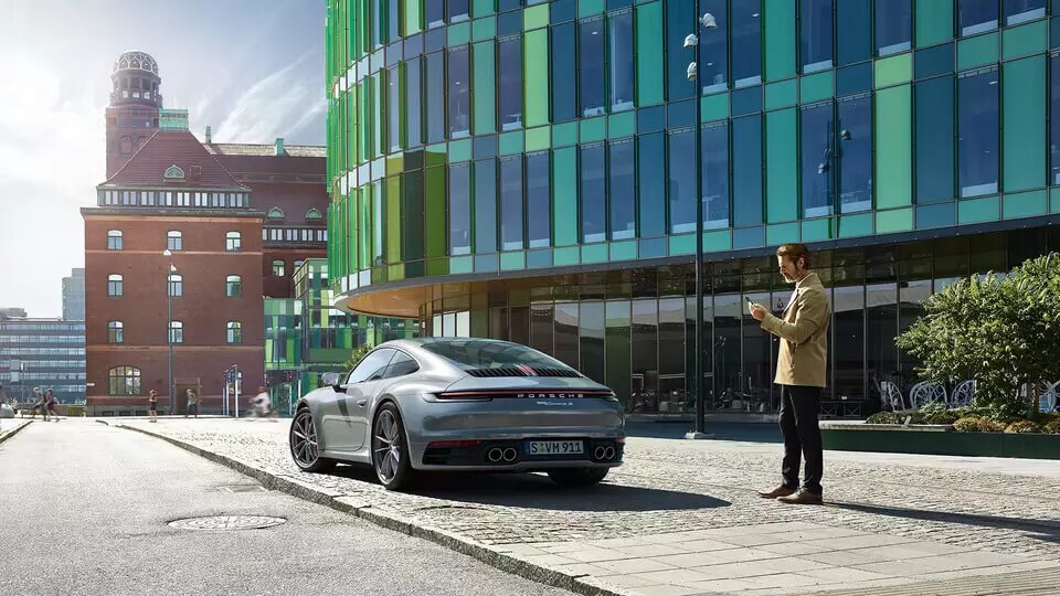 New Porsche 911 with customer standing next to it