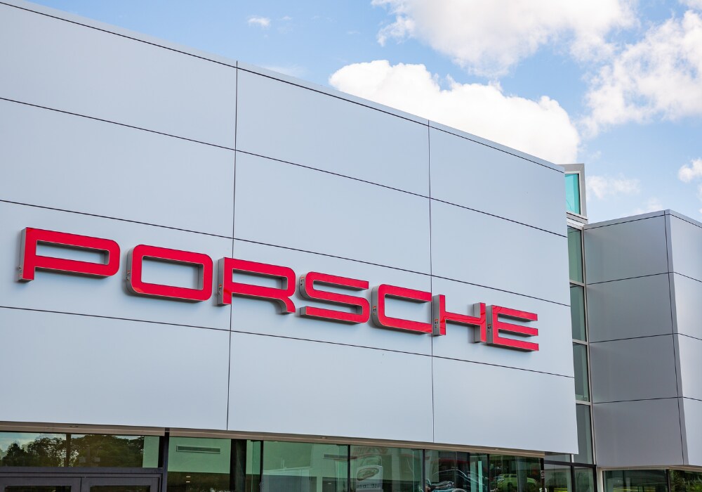 porsche-certified-pre-owned-cars-charlottesville.png Porsche Charlottesville dealership storefront with a red Porsche logo affixed to the building