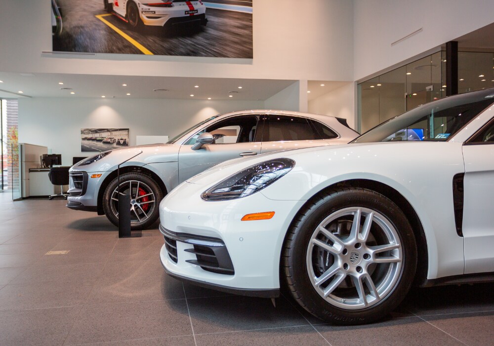 porsche-courtesy-vehicles-charlottesville-va.png Two Porsche SUVs parked inside the showroom at Porsche Charlottesville