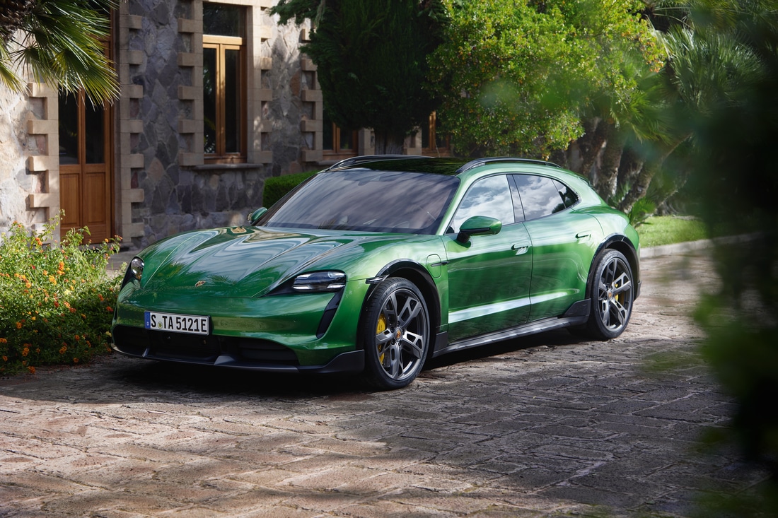 2023-Porsche-Taycan-TurboSCrossTurismo-Sedan-L01.png green Porsche Taycan electric luxury sedan parked near a stone home and greenery