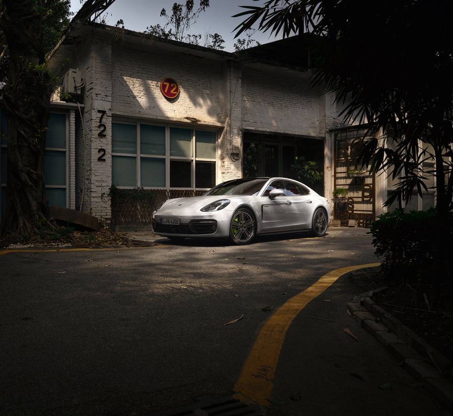2024-Porsche-Panamera-4SEHybrid-Hatchback.png white Porsche Panamera E-Hybrid parked in front of a garage