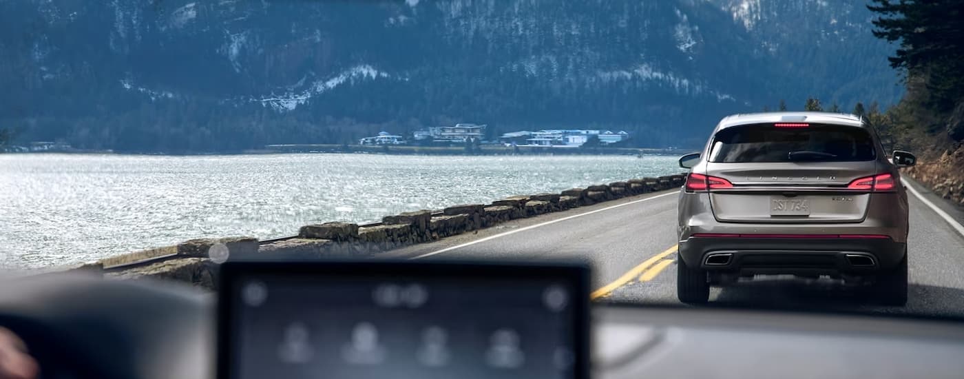 Lincoln Aviator for Sale - 2024 Lincoln Aviator - Infotainment view.jpg A grey 2024 Lincoln Aviator is shown from the rear driving next to a lake.