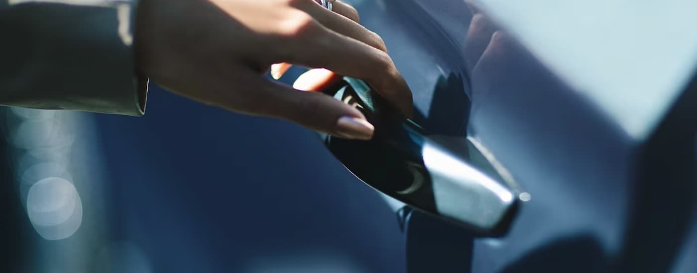 Lincoln Aviator for Sale - 2024 Lincoln Aviator - Handle.jpg A close up of a hand opening the door on a blue 2024 Lincoln Aviator for sale is shown.