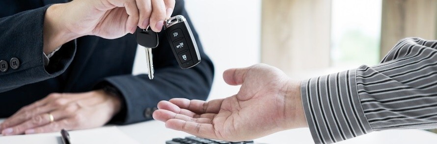 Dealership personnel handing over keys to new used car owner during Used Car Finance at the dealeship.