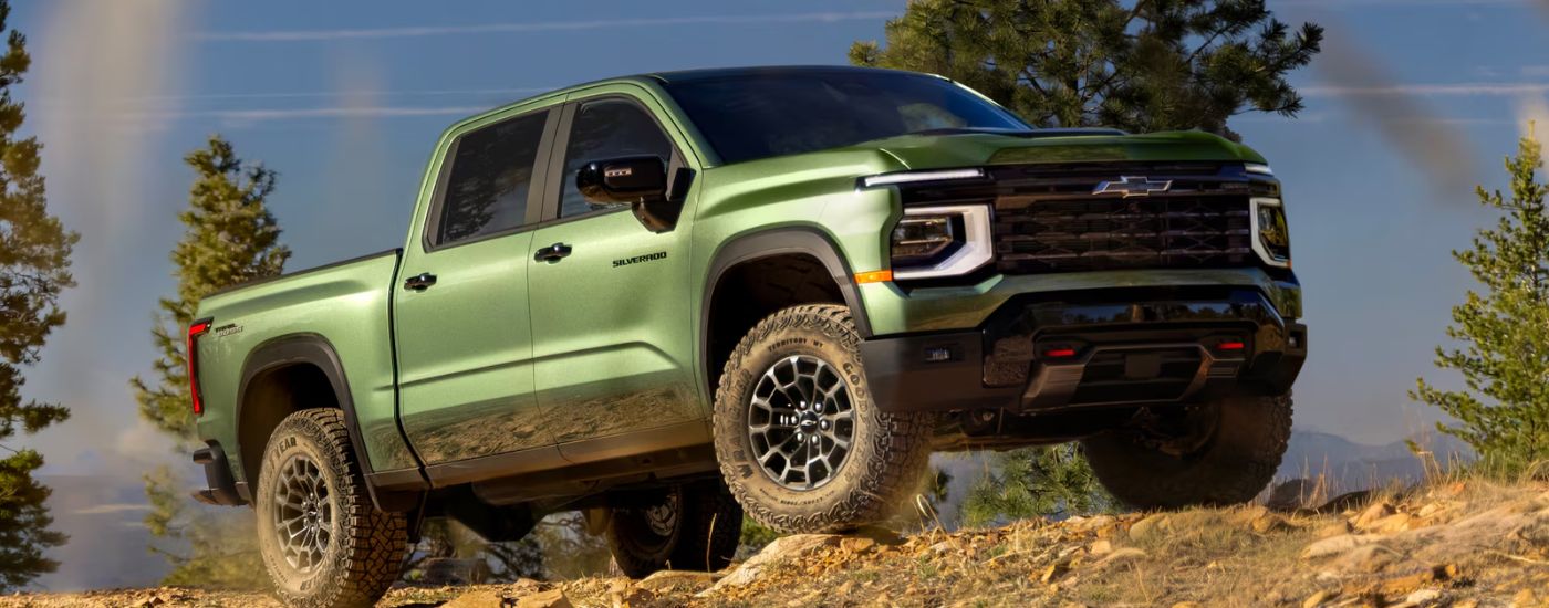 A green 2027 Chevy Silverado 1500 driving off-road.