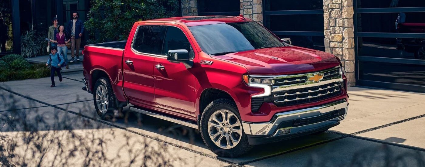 A red 2023 Chevy Silverado 1500 LTZ Z71 parked by a house.