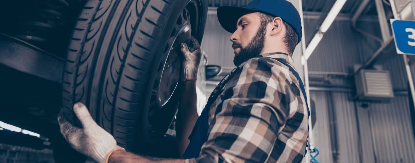 A mechanic changes the tire on a vehicle.