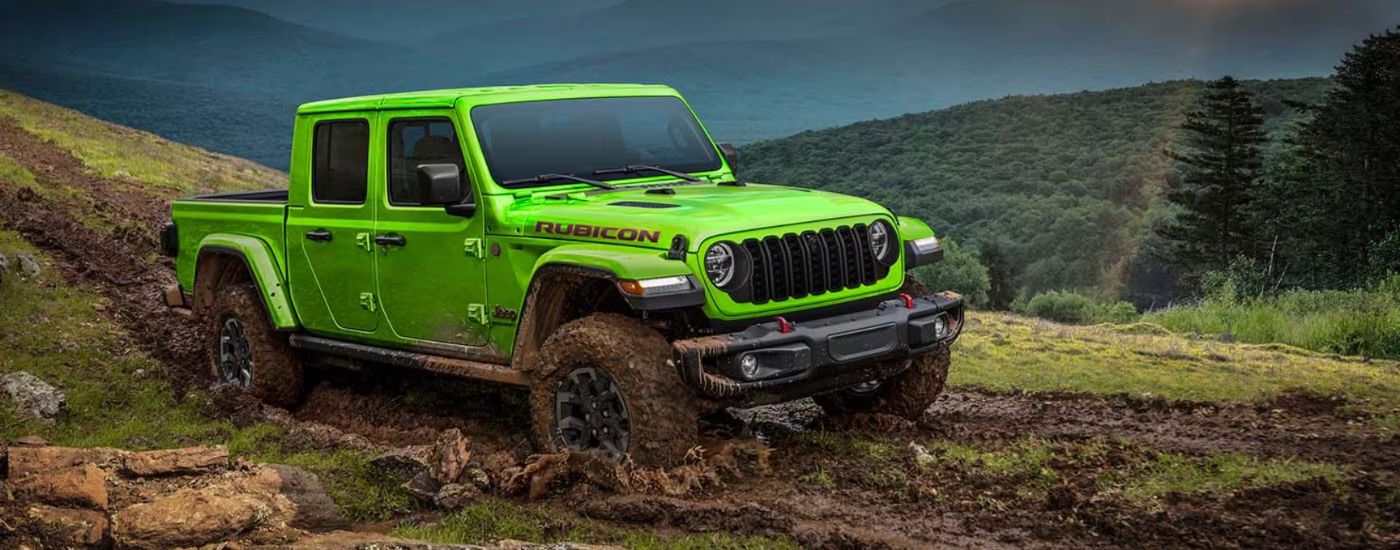 A lime green 2026 Jeep Gladiator Rubicon shown driving through mud.