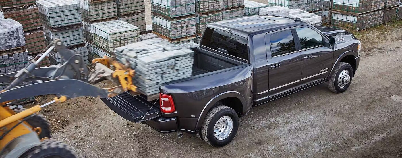 Overhead view of paving stones being loaded into the bed of a grey 2024 Ram 3500.