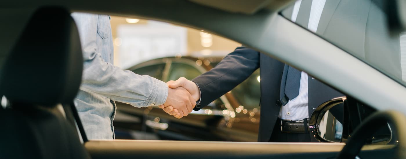 A handshake through a vehicle's window.