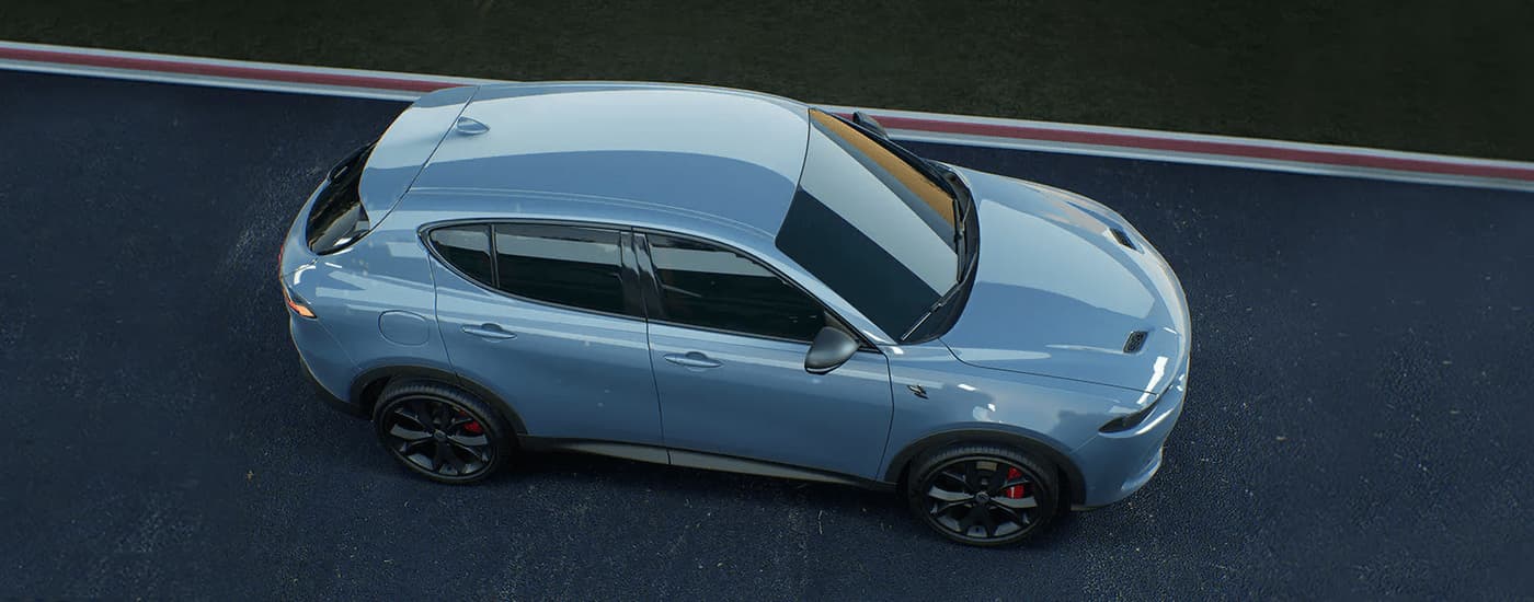 A blue 2023 Dodge Hornet driving on a paved road.